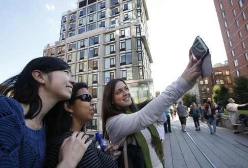 Foreign students in New York pose for a photograph along the High Line. The last stretch of the elevated walkway opened to the public in September. Photo: AP