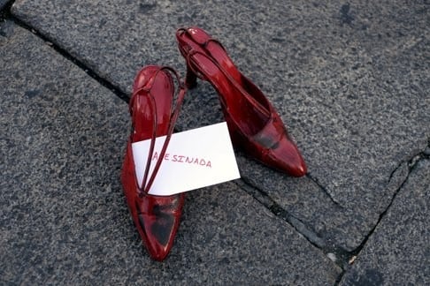 A total of 1,800 red women’s shoes were placed at the Plaza Mayor in Valladolid, Spain, to highlight violence against women. The sign reads “murdered”. Photo: Reuters