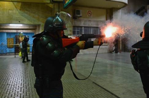 A member of BOPE shoots tear gas at demonstrators during a protest against bus fare increases in February, 2014. Photo: AFP