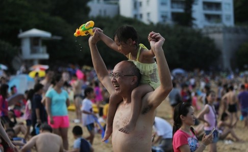 Families enjoy a day out on the beach. Under the new model, it is proposed that the law would no longer grant one parent all the power in making major decisions for the child. Instead, both parents would continue to have responsibility. Photo: Sam Tsang