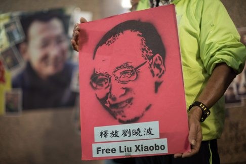 An activist in Hong Kong celebrates the 60th birthday this month of imprisoned human rights activist and Nobel Peace Prize laureate Liu Xiaobo. Photo: EPA