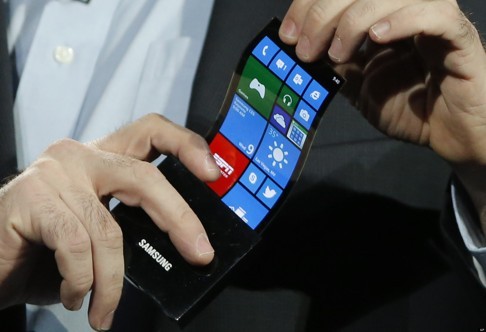 Eric Rudder, chief technical strategy officer of Microsoft, holds a prototype Windows smartphone with a flexible OLED display during Samsung's keynote address at the International Consumer Electronics Show in Las Vegas in this file photo. Photo: AP