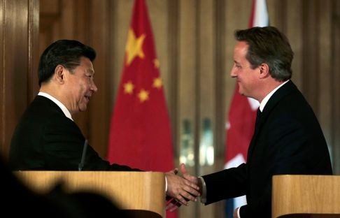 British Prime Minister David Cameron (right) shakes hands with President Xi Jinping in London. China vowed to finance one-third of Britain's first new nuclear power plant in decades in a project led by French energy giant EDF. Photo: AFP
