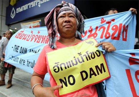 Thai villagers hold banners reading “Love Mekong, No Dam” during a demonstration to protest against the Xayaburi dam in Laos. Photo: EPA