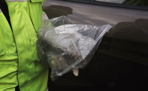 An inspector holding the rock that hit the car. Photo: SCMP Pictures