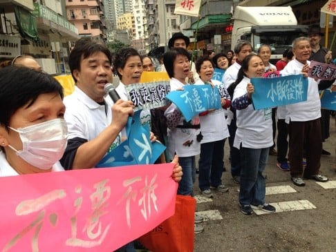 Fabric vendors wave protest banners with phrases such as “I want to buy cheap cloth” near Yen Chow Street Hawker Bazaar in Sham Shui Po.