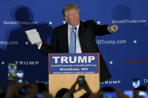 Donald Trump holds a Bible given to him by an audience member at a campaign rally in New Hampshire. Photo: Reuters