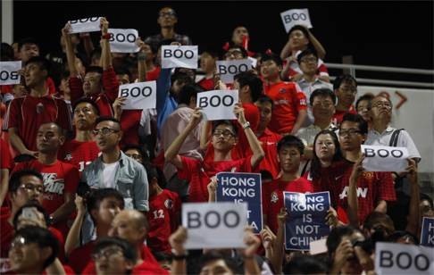 Hong Kong fans hold up signs that read 