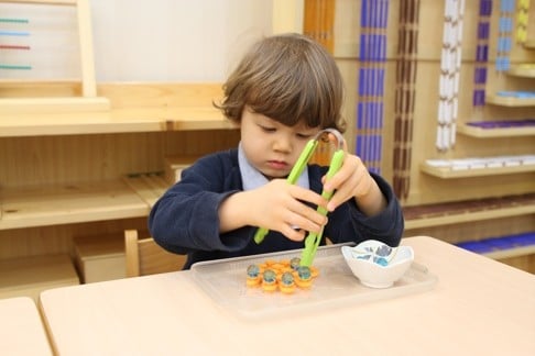 A student performing a hands-on motor control task at the Island Children’s Montessori International Nursery and Kindergarten.