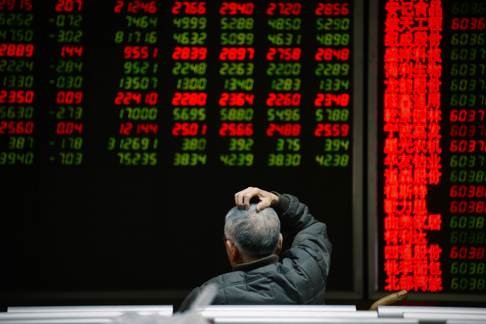 An investor sits in front of screens showing stock market movements at a securities company in Beijing on Thursday. Photo: AFP