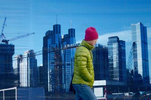 A man walking past a billboard in Beijing. Photo: AFP