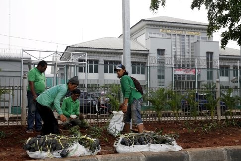 Labourers carry out planting work in front of Cipinang prison. Photo: Reuters