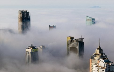 Buildings are seen among fog in Qingdao, Shandong province, March 27, 2015. JLL expects property groups to place more commercial property assets on the market as US interest rates edge higher. Photo: Reuters
