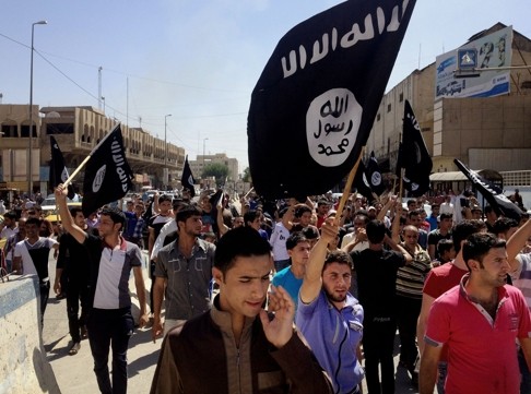 Demonstrators chant pro-Islamic State slogans as they carry the group's flags in Mosul, Iraq. Photo: AP