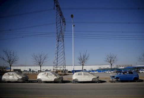 Car frames wrapped in plastic outside a car factory at an industrial complex in Beijing, China. The slowdown has been blamed on weak demand and high costs. Photo: EPA