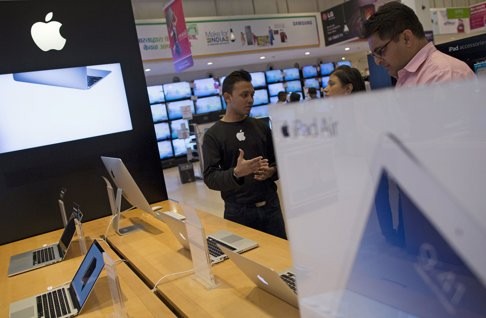 An Apple salesperson speaks to customers at an electronics store in Mumbai. As red-hot sales in China show signs of cooling, Apple executives are touting India's growing appetite for iPhones. Photo: Reuters