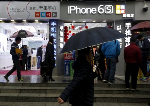 People walk past stores promoting the Apple iPhone 6S in the southern Chinese city of Shenzhen on Tuesday. Apple earns about a quarter of its revenue from Greater China. Photo: Reuters