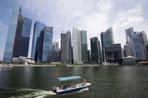 A boat passes in front of skyscrapers in the Marina Bay Financial Centre in Singapore. The city state has consciously sought to attract IT and other professional talent from abroad. Photo: Reuters