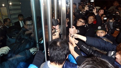 HKU students try to break into the campus venue where governing council members were trapped on Tuesday night. Photo: Sam Tsang