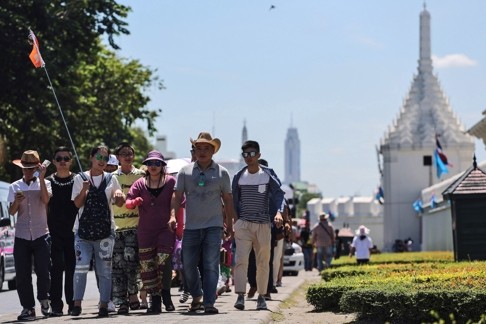 A guide leads a group of tourists from China past the Grand Palace in Bangkok. Thailand has increasingly looked to Chinese investment and visitors as a source of growth. Photo: Bloomberg