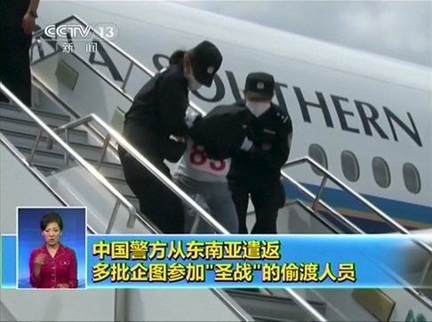 People being deported from Thailand are taken off a plane by police in China last July. China Central Television said they were mostly from Xinjiang and were attempting to join jihadist groups in Syria and Iraq. Photo: Reuters