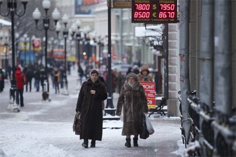 People walk past a currency exchange booth in Moscow. The Russian rouble has dropped to new lows. Photo: AP