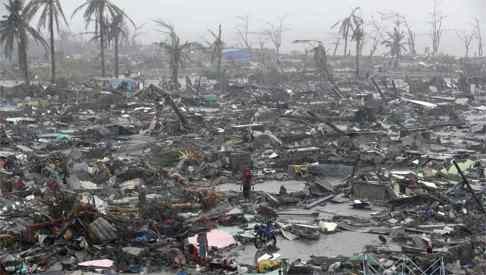 Survivors stand among the ruins of houses destroyed after Super Typhoon Haiyan battered Tacloban city in the central Philippines. Photo: Reuters