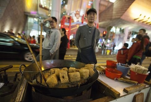 What it was all about? A street hawker sells ‘stinky tofu’ in Portland Street. Hong Kong authorities’ attempts to enforce the law on hawkers selling illegal street food ended in a 10-hour riot. Photo: EPA