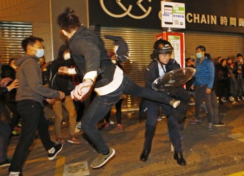 A protester kicks a riot police in Mong Kok district of Hong Kong on Lunar New Year night. Photo: AP