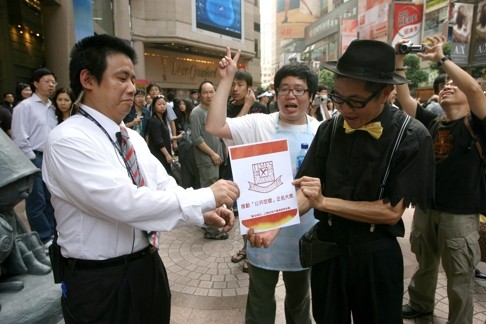 A man presents a Times Square security guard with a fake award certificate to mock the owners of the complex for obstructing the public from using the open piazza in 2008. Photo: K.Y. Cheng