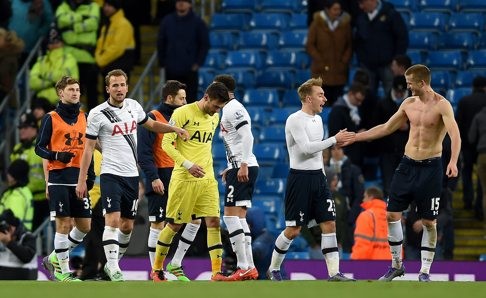 Tottenham players celebrate a hard-fought win which fires them straight into the title race. Photo: EPA