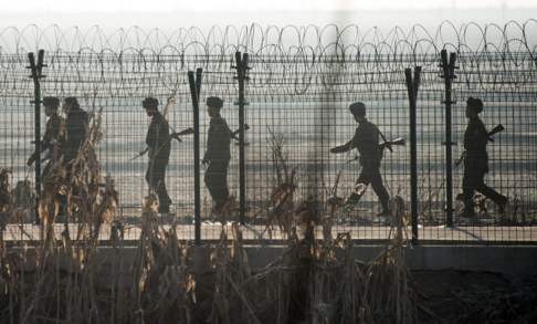 North Korean soldiers patrol the border fence near the town of Sinuiju, across from the Chinese town of Dandong. Photo: AFP