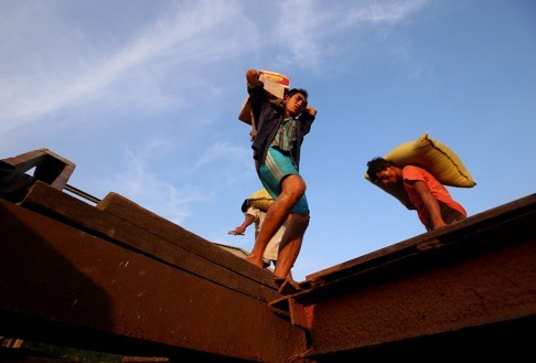 Labourers work at a jetty in Yangon, Myanmar. In the city, the streets are crowded, shops are overflowing, and the media give a sense of what’s going on even if they operate with constraints that might seem repressive. Photo: Xinhua