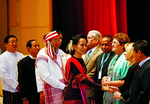 Myanmar’s pro-democracy leader Aung San Suu Kyi shakes hands with foreign parliamentary representatives during a workshop to train newly elected Myanmese lawmakers. Photo: AP