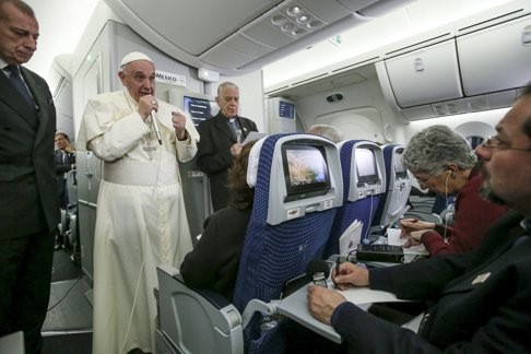 Pope Francis speaks with reporters aboard the Papal plane while en route to Rome on Thursday. Photo: Reuters