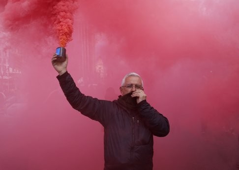 A Spanish taxi driver holds a smoke can during a protest of what drivers called unfair competition from private shared ride businesses like Uber in central Madrid on February 18. The app has sparked a backlash from established taxi companies in various countries around the world. Photo: Reuters