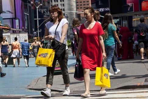 Women carry shopping bags in Times Square, New York. Saving is much higher in China than in the US. China’s saving is 47 per cent of its gross domestic product, compared with America’s 14 per cent. Photo: Reuters