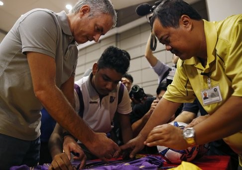 Former Chelsea manager Jose Mourinho signs autographs for students of NorthLight School during a visit in Singapore. Photo: Reuters