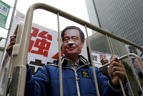 A demonstrator wears a mask depicting Causeway Bay Books shareholder Lee Po during a protest. Photo: Reuters