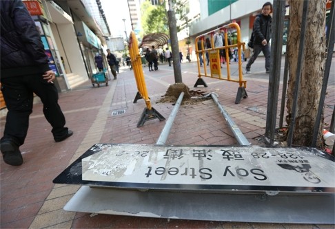 People walk past a damaged street sign after clashes between protesters and police in Mong Kok. Mainland officials are studying the causes of the eruption of violence, Legco president Jasper Tsang says. Photo: Nora Tam