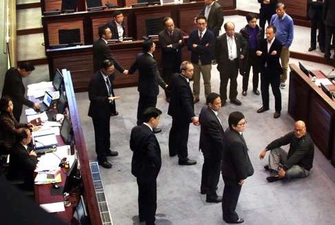 People Power’s Albert Chan seated on the floor and facing security staff during the uproar in Legco. Photo: Felix Wong