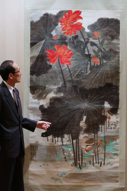 Cheung Chiu-kwan, of Sotheby's, gestures in front of Zhang Daqian’s painting Lotus and Mandarin Ducks following its sale in 2011 for a record HK$191 million. Photo: Dickson Lee