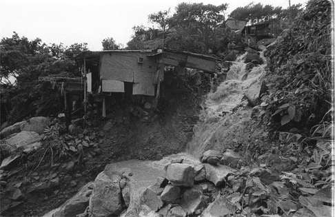 A hut perches precariously on a hill in Chai Wan Kok Village in Tsuen Wan as flood waters gush under it after Typhoon Agnes. Photo: SCMP