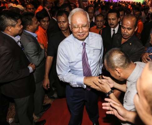 Malaysian Prime Minister Najib Razak shakes hand with his supporters during an event in Kuala Lumpur. Photo: EPA