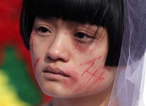 An activist role-plays in Beijing to campaign against domestic violence. Photo: Simon Song