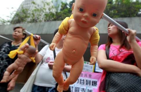 Protesters carry fake babies to protest against the pressures facing career women who have to take care of family and work. Photo: Jonathan Wong