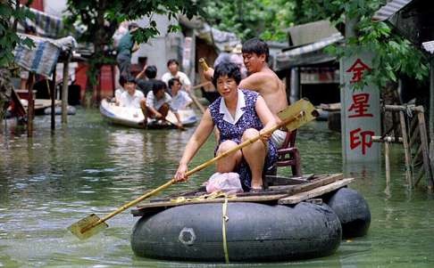 A couple row a makeshift boat amid flooding in Hubei province in 1998. Photo: AP