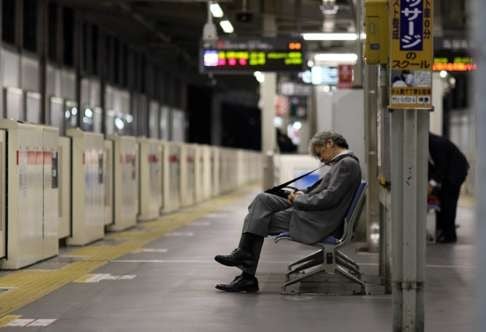 An office worker sleeps on a bench at a Tokyo train station. Critics say enforcement of Japan’s labour laws is too weak and workers are being forced to endure many hours of unpaid overtime. File photo: AFP