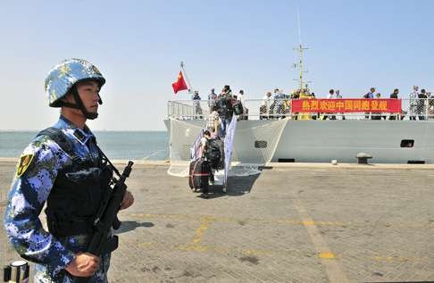 A Chinese sailor stands guard as Chinese citizens board the PLA naval ship “Linyi” at a port in Aden, Yemen, in this March 29, 2015 file photo. The operation was to evacuate Chinese citizens from the war-torn country; more Chinese military traffic is likely in the same waters after the PLA’s naval base in nearby Yemen opens. Photo: Reuters