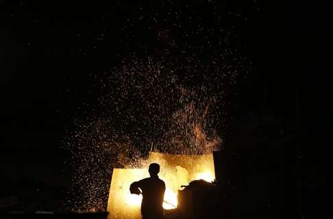 A worker produces aluminium ingots at a mill in Zhejiang province. Photo: Reuters